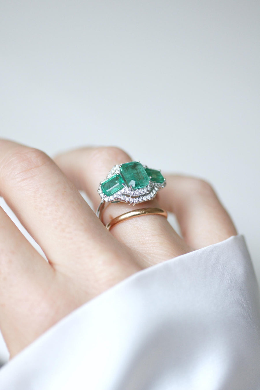 Ring Three Emeralds Surrounded by Diamonds on White Gold