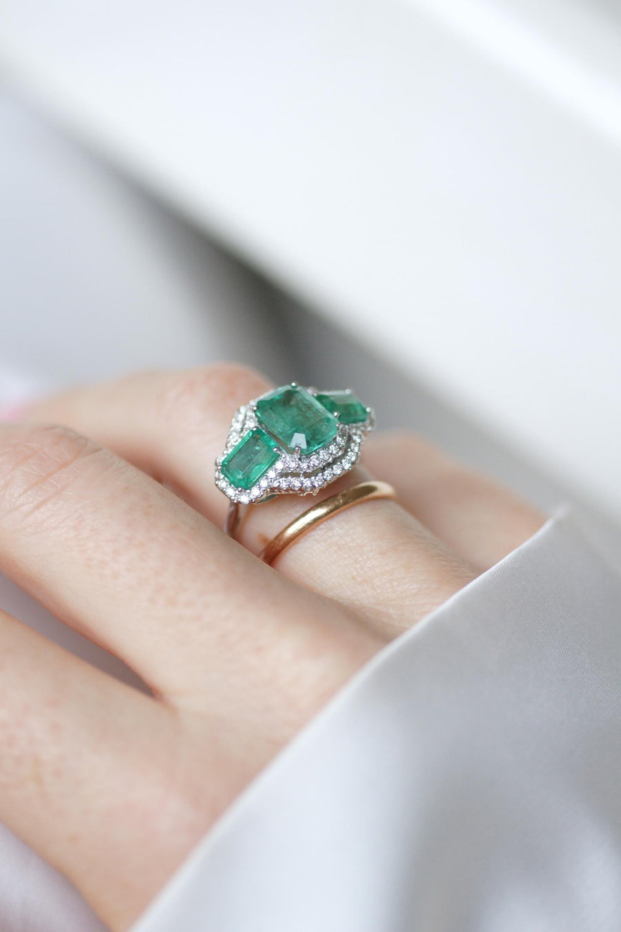Ring Three Emeralds Surrounded by Diamonds on White Gold