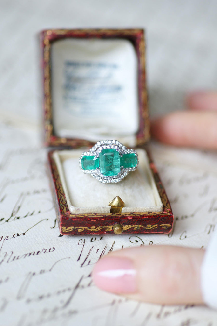 Ring Three Emeralds Surrounded by Diamonds on White Gold