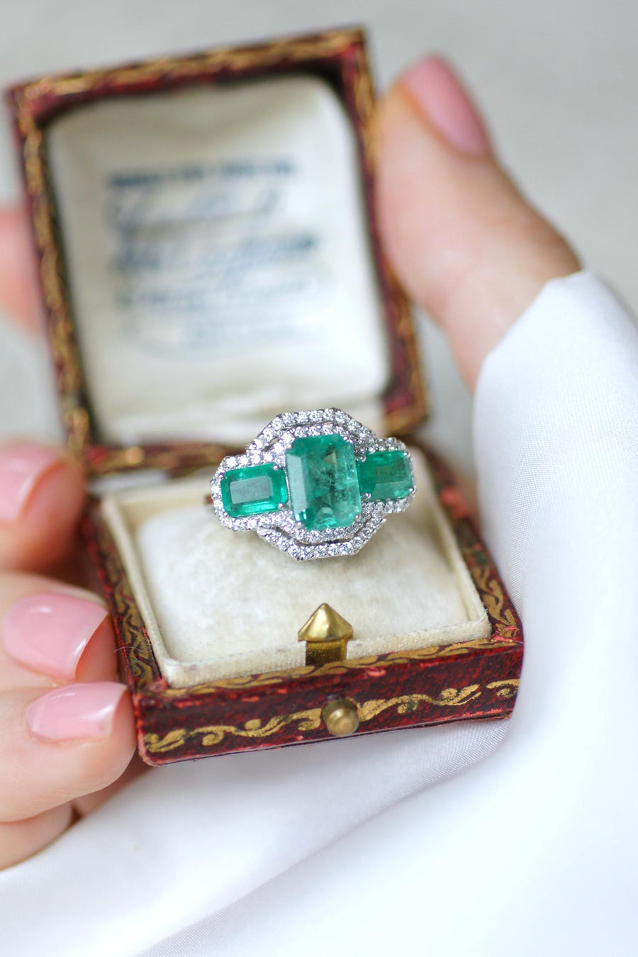 Ring Three Emeralds Surrounded by Diamonds on White Gold