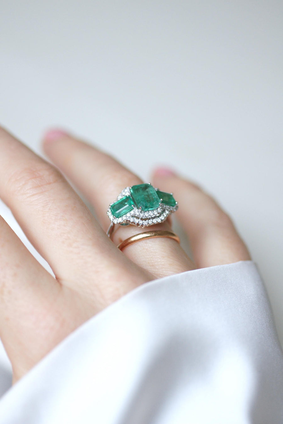Ring Three Emeralds Surrounded by Diamonds on White Gold